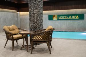 a table and chairs next to a swimming pool at Al Anvar Halal Hotel by HotelPro group in Tashkent