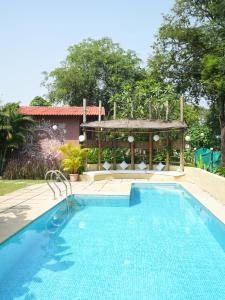 a swimming pool with a gazebo and a swimming pool at Tamarind Retreat in Alibaug