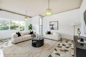 a living room with two white couches and a table at Comfortable House-shared accommodation in Bankstown