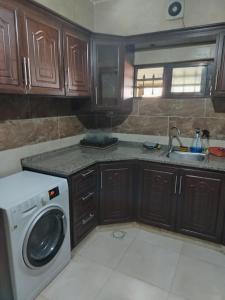 a kitchen with a washing machine and a sink at الشقة العائلية الحديثة familial new flat in Amman