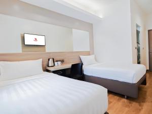 a hotel room with two beds and a desk at Red Planet Ortigas in Manila +32 photos