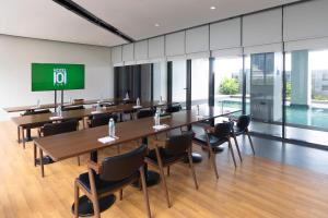a conference room with tables and chairs and a screen at Hotel101 - Fort in Manila +21 photos