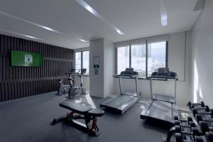 a gym with several tread machines in a room with chairs at Hotel101 - Fort in Manila
