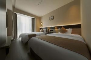a hotel room with two beds and a window at Good Night Hotel in Zhangjiajie