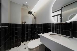 a bathroom with a sink and a toilet and a mirror at Good Night Hotel in Zhangjiajie +65 photos