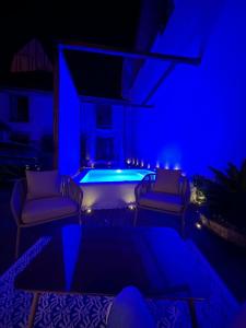 a blue room with a pool with chairs and a table at La Galerie - Mini Piscine - Bourges Originale in Bourges +27 photos