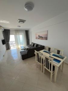 a living room with a black couch and a table at PARADISE APARTMENT in Sarandë