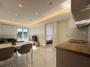 a kitchen with a table and chairs and a living room at MELISSA Suites By SDR in Paralia Katerinis