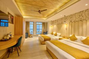 a hotel room with two beds and a desk at Hotel Katson Castle with Sunset View Dharamshala in Dharamshala +32 photos