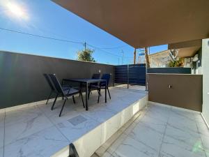 a patio with a table and chairs on a balcony at MELISSA Suites By SDR in Paralia Katerinis +5 photos