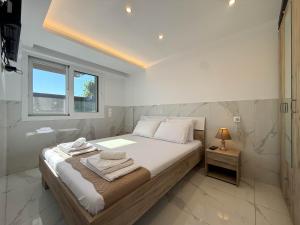 a bedroom with a bed and a window and a lamp at MELISSA Suites By SDR in Paralia Katerinis