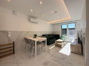 a living room with a table and a green couch at MELISSA Suites By SDR in Paralia Katerinis