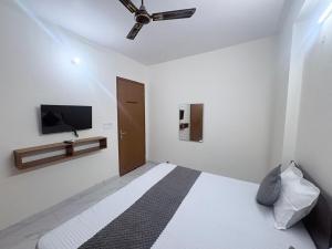 a bedroom with a bed with a ceiling fan and a tv at Hotel 69 in Gurgaon