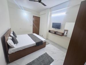 a bedroom with a bed and a flat screen tv at Hotel 69 in Gurgaon +20 photos