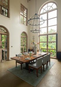 a dining room table with chairs and a chandelier at LohonoStays Villa Floresta in Assagao