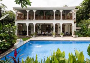 a house with a swimming pool in front of a house at LohonoStays Villa Floresta in Assagao +12 photos