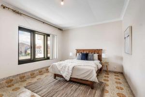 a white bedroom with a bed and a window at Comfortable House-shared accommodation in Bankstown