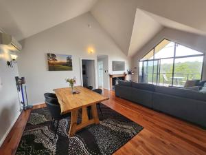 a living room with a table and a couch at Scarlet Woods Chalets in Quinninup