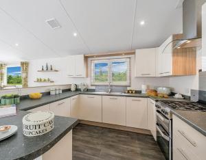 a kitchen with white cabinets and a stove top oven at Shrimp Shack in Heysham