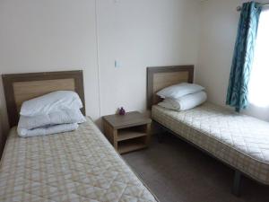 a room with two beds and a table and a window at Shrimp Shack in Heysham