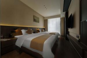 a large bedroom with two beds and a window at Good Night Hotel in Zhangjiajie