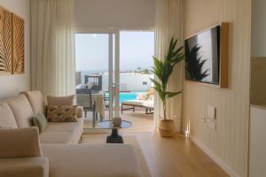 a living room with a couch and a table with a view at Serena del Mar by LIVVO in Playa Blanca