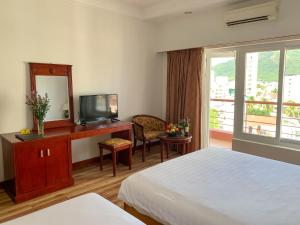 a hotel room with a bed and a desk with a mirror at Media Nha Trang Hotel in Nha Trang