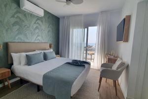 a bedroom with a bed and a chair and a window at Serena del Mar by LIVVO in Playa Blanca +18 photos