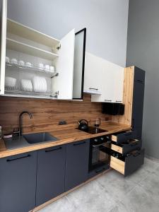 a kitchen with white cabinets and a sink at Cottages Grun in Yablunytsya