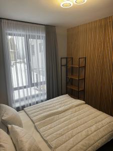a bedroom with a large bed and a window at Cottages Grun in Yablunytsya