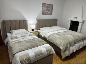 two beds sitting next to each other in a bedroom at Bujtina Kenedi in Korçë