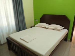 a bed with two pillows on it in a bedroom at isha homestay in Varkala +15 photos