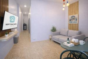 a living room with a couch and a table at Soft Blue Home, Krabi Town in Krabi