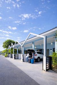 two people are standing outside of a car dealership at Soft Blue Home, Krabi Town in Krabi