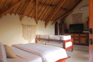 a bedroom with a bed and a tv in a room at Sea Turtle Villas in Gili Islands