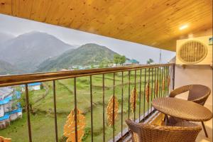 a balcony with two chairs and a view of a mountain at Hotel Katson Castle with Sunset View Dharamshala in Dharamshala