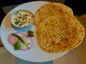 a plate with two naan bread and a bowl of soup at Hotel 69 in Gurgaon
