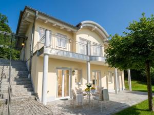 a large white house with a table and chairs at Bergperle am Lindberg in Perlesreut