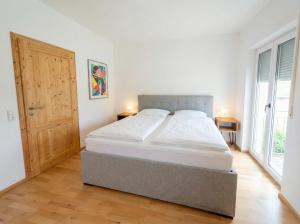 a bedroom with a large bed and a wooden floor at Bergperle am Lindberg in Perlesreut