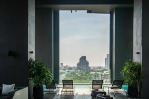 a room with chairs and a large window at Ascott Thonglor Bangkok in Bangkok