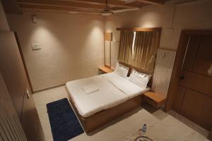 a small bedroom with a bed and a blue rug at Greenland Resort in Silvassa