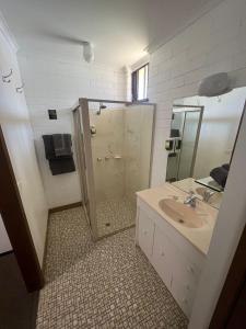 a bathroom with a shower and a sink and a mirror at Orana Motor Inn in Mildura +21 photos
