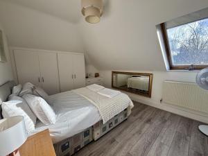 a bedroom with a large bed and a mirror at Egham Modern Two Bedroom Apartment in Egham
