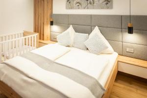 a bed with white sheets and pillows in a room at Traumferienhaus XXL Ortner in Wetzendorf