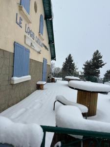 a building with snowcovered tables and benches in front of it at Aupalya Gîte Le Logis Catalan in Font-Romeu