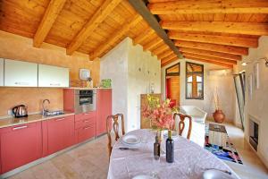 a kitchen with red cabinets and a table at Villa Casa Lucia by PosarelliVillas in Tavarnelle Val di Pesa