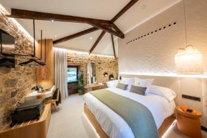 a bedroom with a bed and a desk in a room at Hotel Sarela Natura in Santiago de Compostela +25 photos