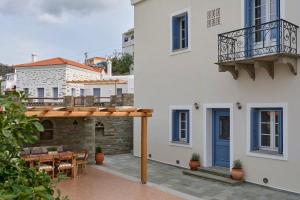 a white building with a blue door and a patio at Alaia Boutique houses in Batsi