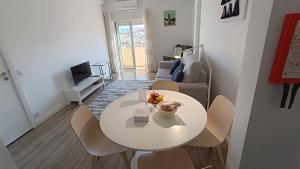 a living room with a white table and a couch at Coimbra's Black & White in Coimbra