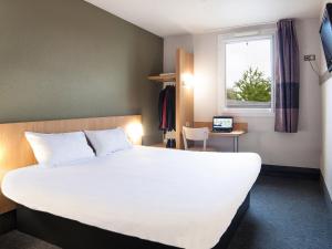 ブシー・サン ・ジョルジュにあるB&B HOTEL Marne-la-Vallée Bussy-Saint-Georgesの大きなベッドと窓が備わるホテルルームです。